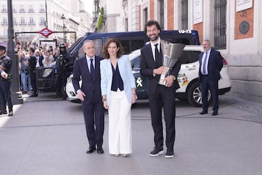 El capitán del Real Madrid de baloncesto, Sergio Llull, sostiene el trofeo de campeón de la Euroliga junto a la presidenta de la Comunidad de Madrid, Isabel Díaz Ayuso y el presidente del Real Madrid, Florentino Pérez.