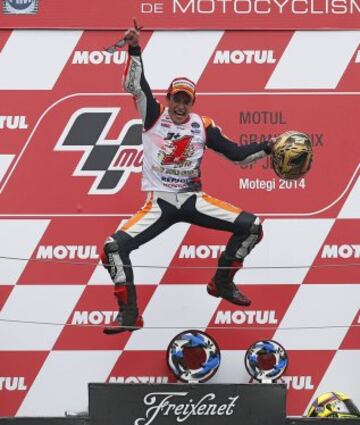 Honda MotoGP rider Marc Marquez of Spain jumps into the air on the podium after he finished in second place to become the 2014 world champion at the Japanese Grand Prix at the Twin Ring Motegi circuit in Motegi, north of Tokyo October 12, 2014. Spaniard Marc Marquez retained his MotoGP world title with a second place finish at his team Honda's home Motegi circuit in the Japanese Grand Prix on Sunday.  REUTERS/Toru Hanai (JAPAN - Tags: SPORT MOTORSPORT)