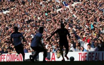 Mientras los seguidores del Tottenham intentan zafarse del sol con las manos, un jugador de su equipo se desplaza como una sombra por el campo.