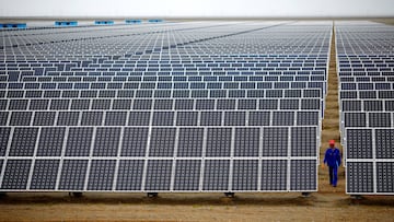 FILE PHOTO: A worker inspects solar panels at a solar farm in Dunhuang, 950km (590 miles) northwest of Lanzhou, Gansu Province September 16, 2013. Picture taken September 16, 2013. REUTERS/Carlos Barria/File Photo