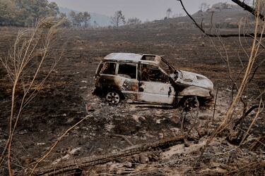 Un coche carbonizado durante el incendio forestal en Pareisas.