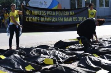 Miembros de Amnistía Internacional (AI) se manifestaron en frente del Comité Olímpico Internacional en Río para pedir justicia tras la muerte de 40 personas, supuestamente por violencia policial, en el mes de mayo.