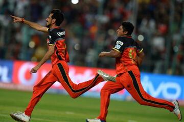 Royal Challengers Bangalore players Yuzvendra Chahal (L) and Sarfaraz Khan run to the field to celebrate the teams victory.