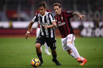Juventus' forward Paulo Dybala from Argentina (L) fights for the ball with AC Milan's midfielder Lucas Biglia from Argentina during the Italian Serie A football match AC Milan Vs Juventus on October 28, 2017 at the 'Giuseppe Meazza' Stadium in Milan.