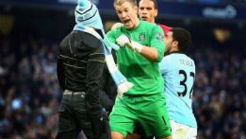 Joe Hart, portero del City, se enfrenta a un aficionado que salt&oacute; al campo durante el derbi del pasado domingo. 