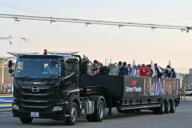 Los pilotos de Fórmula Uno se suben a la parte trasera de un camión para el desfile de pilotos antes de la carrera. 