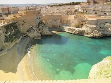 Una pequeña cala escondida entre las murallas de la ciudad vieja. Recientemente regenerada con arena dorada, ofrece aguas tranquilas y un ambiente muy acogedor. Es ideal para quienes buscan tranquilidad y un rincón histórico frente al mar.
