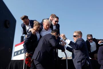 El expresidente, Donal Trump, es evacuado por el servicio secreto del estrado, con algo de sangre en el rostro, tras escucharse disparos. El candidato republicano ha salido por su propio pie con el pu?o en alto.