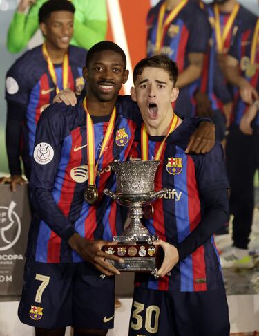 Dembelé y Gavi con el trofeo en sus manos.