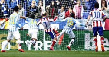 El delantero francés del Atlético de Madrid Antoine Griezmann, marca gol ante el defensa marfileño del Málaga Arthur Boka, durante el partido de la trigésimo primera jornada de Liga