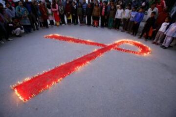 Un grupo de personas rodeando un lazo rojo en Kathmandu, Nepal.