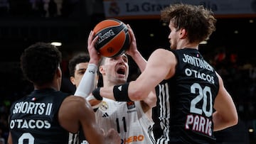 El alero del Real Madrid Mario Hezonja (c) trata de jugar un balón entre TJ Shorts (i) y Mikael Jantunen, ambos del París Basketball, durante el partido de la jornada 33 de la EuroLiga de baloncesto que Real Madrid y París Basketball disputan este jueves en el Movistar Arena.