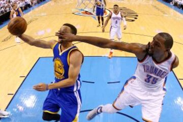 Stephen Curry intenta encestar ante la oposición de Kevin Durant en la eliminatoria final de la conferencia oeste de la NBA.