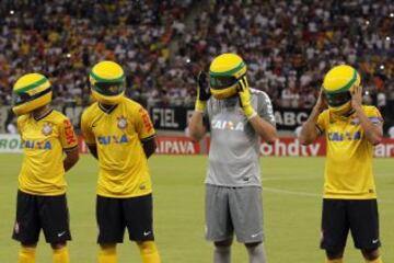 Los jugadores de fútbol del  Corinthians salen al terreno de juego con una replica del casco usado por  Ayrton Senna como homenaje al piloto de fórmula uno en la víspera del 20 º aniversario de su muerte, durante una carrera de F1 en Imola, Italia. 