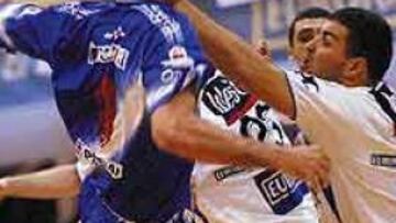 <b>SIN MIRAMIENTOS.</B> Garralda intenta el lanzamiento soportando el zarpazo durísimo de Gyula Gal.