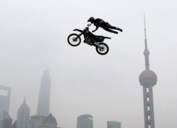 Un competidor realiza un salto de motocross extremo con el horizonte de Shanghai de la zona histórica de Bund en Shanghai el 27 de abril de 2014, para dar inicio a los Juegos Mundiales Extreme Kia. Los juegos se destaca casi 200 de los mejores atletas de deportes de acción de cerca de 30 países y regiones, compitiendo en BMX freestyle, agresivo, patinaje, escalada de velocidad en línea y la competencia internacional de motocross freestyle.