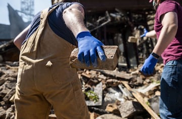 MINNEAPOLIS, MN - MAY 30: People work to clean up outside a burned building on May 30, 2020 in Minneapolis, Minnesota. Buildings and businesses around the Twin Cities have been looted and destroyed in the fallout after the death of George Floyd while in police custody. Police Officer Derek Chauvin has been charged with third-degree murder and manslaughter in Floyd's death. Stephen Maturen/Getty Images/AFP == FOR NEWSPAPERS, INTERNET, TELCOS & TELEVISION USE ONLY ==