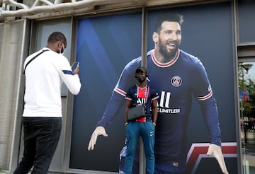 Los fans del PSG se fotografían con las imágenes de Messi alrededor del estadio parisino.