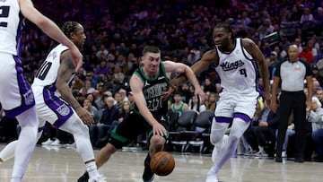Boston Celtics guard Payton Pritchard (11) dribbles the ball while defended by Sacramento Kings forward Precious Achiuwa (9) and forward DeMar DeRozan (10) during the first quarter at Golden 1 Center.