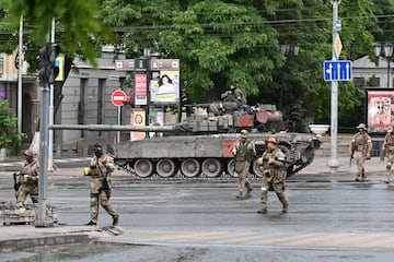 Los combatientes del grupo mercenario privado de Wagner cruzan una calle mientras se despliegan cerca de la sede del Distrito Militar Sur en la ciudad de Rostov.