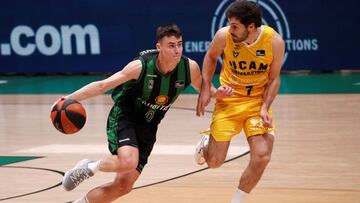 BADALONA (BARCELONA), 23/12/2020.- El base macedonio del Joventut Nenad Dimitrijevic (i) intenta superar al base del UCAM Murcia Tomás Bellas durante el partido de la liga Endesa que se disputa este miércoles en el Olimpic de Badalona. EFE/Alejandro García