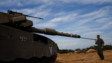 An Israeli soldier cleans the barrel of a tank, amid the ongoing conflict between Israel and the Palestinian Islamist group Hamas, near the Israeli-Gaza Border, as seen from Israel, December 8, 2023. REUTERS/Amir Cohen
