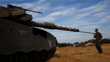 An Israeli soldier cleans the barrel of a tank, amid the ongoing conflict between Israel and the Palestinian Islamist group Hamas, near the Israeli-Gaza Border, as seen from Israel, December 8, 2023. REUTERS/Amir Cohen