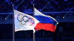 (FILES) This file photo taken on February 23, 2014 shows the Olympic flag and the Russian flag flying during the Closing Ceremony of the Sochi Winter Olympics at the Fisht Olympic Stadium. Russia's anti-doping chief Yury Ganus said on November 26, 2019 he