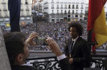 El capitán del Real Madrid Iker Casillas (i) hace una foto al brasileño Marcelo en la sede del Gobierno de la Comunidad de Madrid, en la Puerta del Sol, durante las celebraciones del equipo blanco tras la victoria en la final de la Liga de Campeones disputada ayer en Lisboa. 