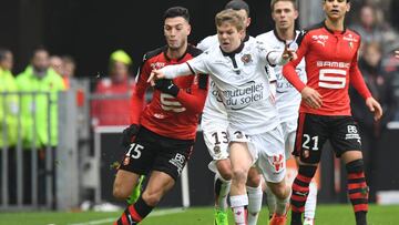 Vincent Koziello, de blanco con el Niza, disputa un balón con un jugador del Rennes, de rojo.