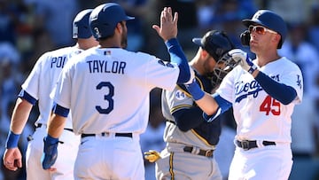 Los Angeles Dodgers first baseman Matt Beaty (45) crosses the plate scoring left fielder AJ Pollock (11) and left fielder Chris Taylor (3) after hitting a three run home run in the eighth inning against the Milwaukee Brewers at Dodger Stadium.