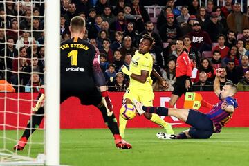 El jugador del Villarreal Chukwueze dispara a la portería del Barcelona ante la mirada de Jordi Alba y Ter Stegen.
 