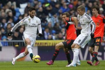 El centrocampista del Real Madrid Francisco Alarcón "Isco" con el balón ante el delantero de la Real Sociedad Sergio Canales y su compañero, el alemán Toni Kroos, durante el partido de la vigésimo primera jornada de Liga de Primera División.