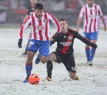 Aguero zafándose de un contrario, con el terreno de juego nevado, durante un partido de la Europa League entre el Bayern Leverkusen y el Atlético de Madrid en diciembre de 2010