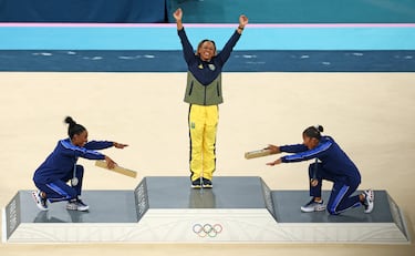 Jordan Chiles y Simone Biles del equipo de Estados Unidos homenajean a la medallista de oro Rebeca Andrade del equipo de Brasil en la ceremonia de entrega de medallas de gimnasia artística femenina.