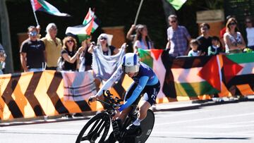 Cycling - Vuelta a Espana - Stage 18 - Valladolid to Valladolid - Valladolid, Spain - September 11, 2025 Israel - Premier Tech's Jake Stewart in action as pro-Palestine protestors are pictured in the background REUTERS/Juan Medina