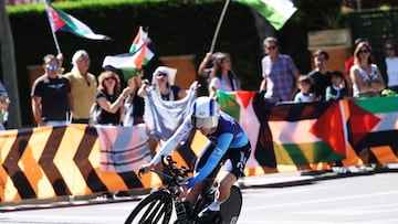 Cycling - Vuelta a Espana - Stage 18 - Valladolid to Valladolid - Valladolid, Spain - September 11, 2025 Israel - Premier Tech's Jake Stewart in action as pro-Palestine protestors are pictured in the background REUTERS/Juan Medina
