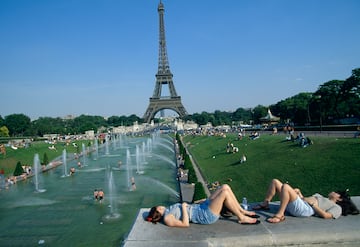 Tourists enjoy the Parisien heat as a tower grows in the background.