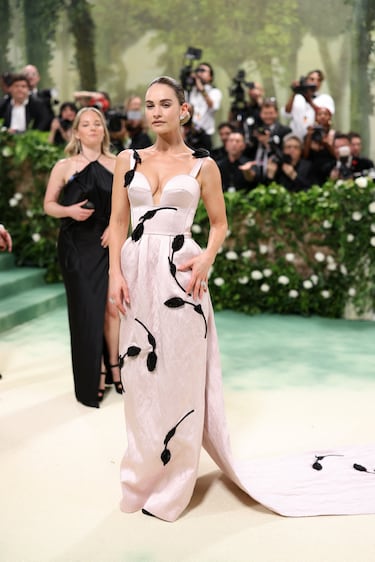 La actriz, Lily James, posa con un vestido rosa y detalles florales negros de Erdem.