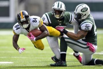 El jugador de los Pittsburgh Steelers, Antonio Brown (84) intenta irse de los jugadores de los New York Jets, Dawan Landry (26) y Antonio Allen (39).
