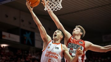 GIRONA (ESPAÑA), 17/05/2025.- El alero del Valencia Basket Xabi López-Arostegui (i) entra a canasta defendido por Mindaugas Susinskas, del Básquet Girona, durante el partido de la Liga Endesa de baloncesto que se disputa este sábado en el pabellón de Fontajau de Girona. EFE/David Borrat.