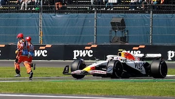 Los dos comisarios cruzan la pista delante del coche de Liam Lawson durante el GP de México.