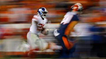 DENVER, CO - OCTOBER 15: Running back Orleans Darkwa #26 of the New York Giants runs with the football for a long gain as strong safety Justin Simmons #31 of the Denver Broncos defends during the second quarter at Sports Authority Field at Mile High on October 15, 2017 in Denver, Colorado.   Justin Edmonds/Getty Images/AFP
 == FOR NEWSPAPERS, INTERNET, TELCOS &amp; TELEVISION USE ONLY ==