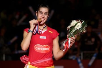 Carolina imitando el gesto de su ídolo Rafa Nadal: morder la medalla.