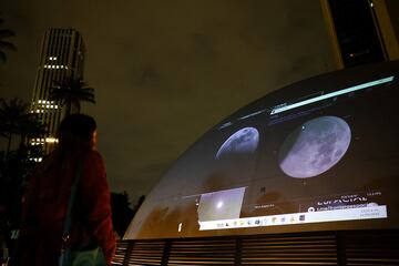 La gente se re¨²ne en el techo del planetario distrital para ver un eclipse lunar en Bogot¨¢, Colombia.
