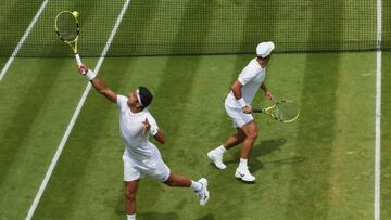 LONDON, ENGLAND - JULY 03: Robert Farah (L) plays a backhand with partner Juan Sebastian Cabal of Colombia against Radu Albot of Moldova and Nikoloz Basilashvili of Georgia during their Men's Doubles Third Round match on day seven of The Championships Wimbledon 2022 at All England Lawn Tennis and Croquet Club on July 03, 2022 in London, England. (Photo by Julian Finney/Getty Images)