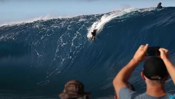 Un bodyboarder realiza el drop en una ola gigante en Teahupoo (28 de mayo del 2022), Tahit¨ª;, Polinesia Francesa, en la sesion de surf de olas gigantes que marcara una era. Dos personas en un barco se lo miran y graban con el tel¨¦fono mientra