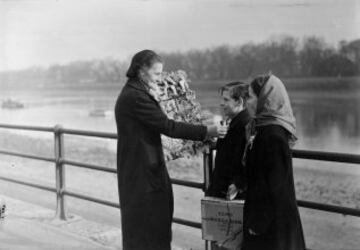 Una mujer vende rosetas antes de la regata del 1 de Abril de 1950.