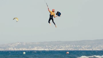 Una kitesurfista aguanta con su mano la tabla de kitesurf strapless en Tarifa (C&aacute;diz).