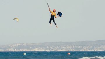 Una kitesurfista aguanta con su mano la tabla de kitesurf strapless en Tarifa (C&aacute;diz).